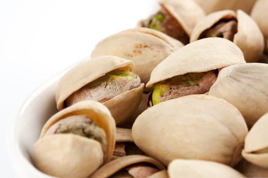 Close-up roasted and salted pistachios on white plate