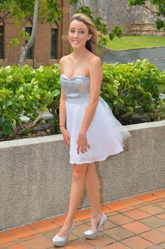 Attractive young lady dressed in a sparkling silver and white ballet tutu with matching high heeled shoes.