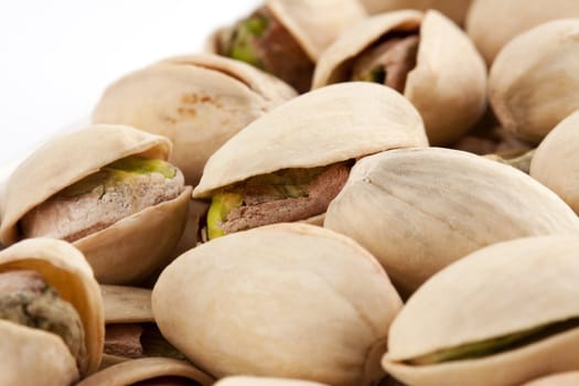 Close-up roasted and salted pistachios on white plate
