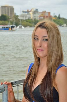 Attractive teenage girl in the foreground. The background showing the Brisbane River with one of Brisbane's City Cats passing.