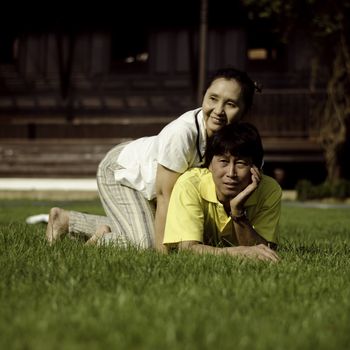 Portrait of beautiful couple lie on ground in park relaxing