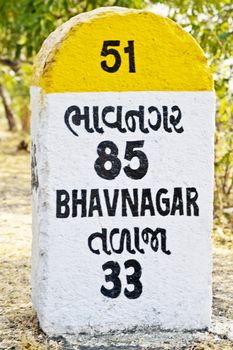 Location of this vertical close crop framed shot was on route to Bhavnagar from Dwarka,  85 kilometer milestone direction sign and landmark