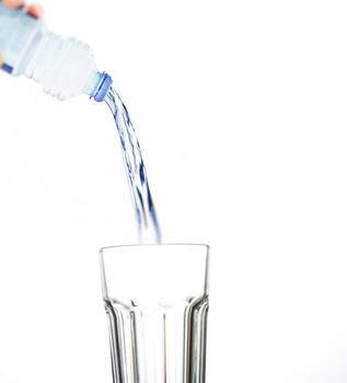 pouring water on glass on white background