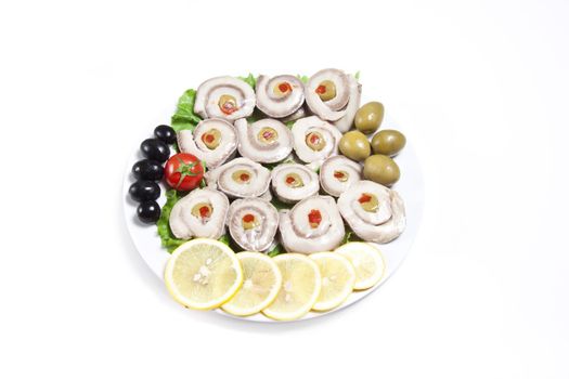 fish slices served with tomato and olives, and lemon