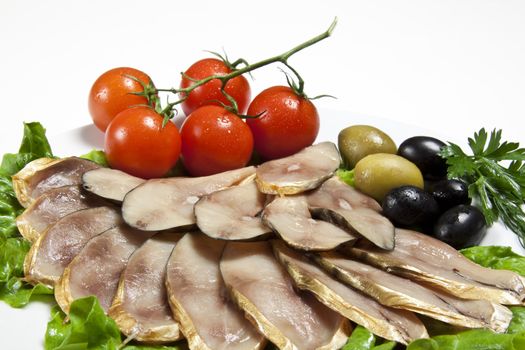 slices smoked fish served with tomato and olive