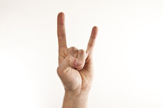 A man's hand giving the Rock and Roll sign.