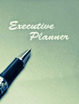 executive planner and pen splitted tone from red in portrait orientation