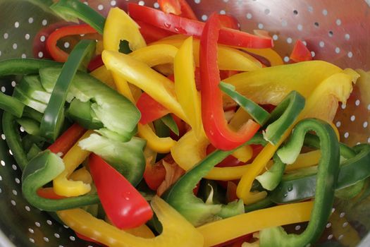 many pepper slices on a wooden background