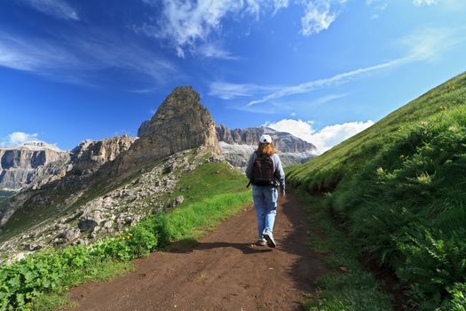 hiker walks on a path in Fassa Valley, Italian Dolomites