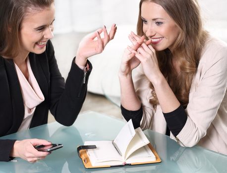 Two girls sitting at a glass table