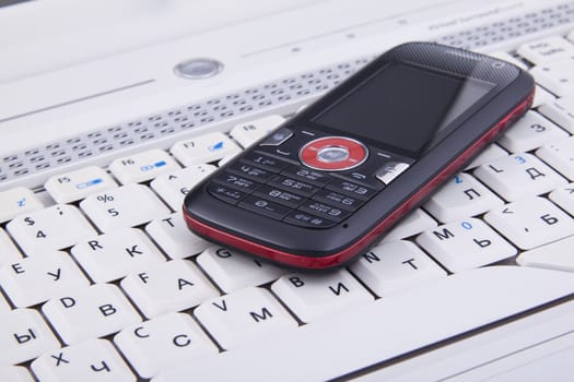 Business concept - mobile phone over laptop keyboard