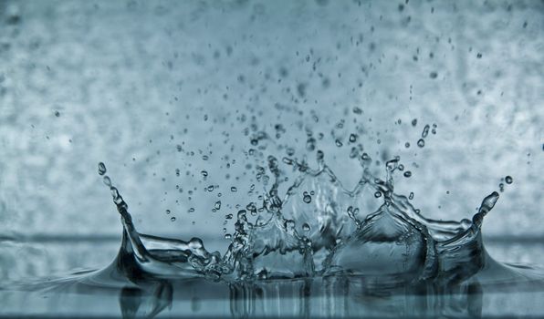 Sparks of blue water on a gray background