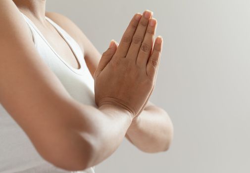 A beautiful Young Indian girl in white top doing meditation by joining hands