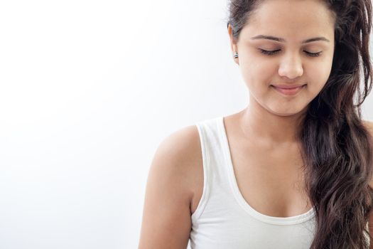 A beautiful Young Indian girl in white top doing meditation