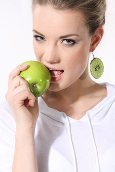 Girl with a green apple on a white background