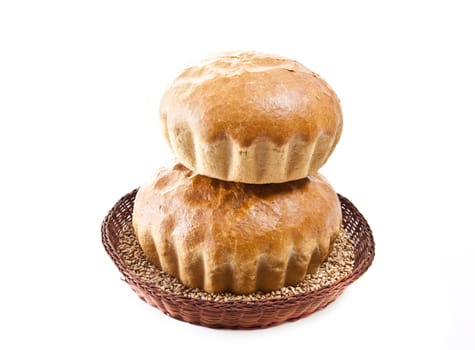two fresh baked rolls with grain in a basket on white
