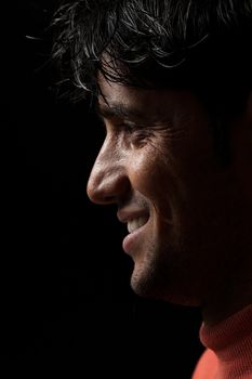 Grains & textures are added in the portrait of Indian man smiling over dark background