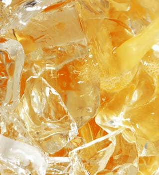 orange juice with ice cubes close up