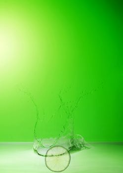 lime in the water splash on green background