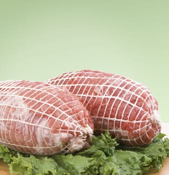 Two big pieces of fresh ham on green leaves