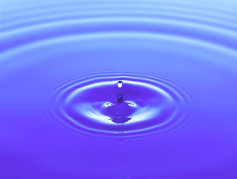 Droplet falling in water close up background