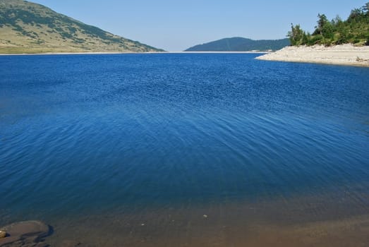 Clear dam lake blue waters in summer