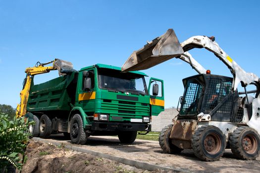 Two excavators loaded dumper at construction site
