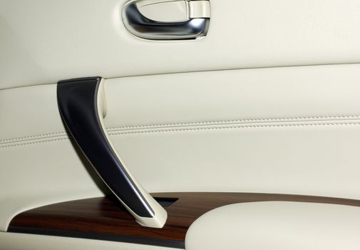 Interior of modern japanese car. Door made of leather, wood and aluminium. As background or backdrop.