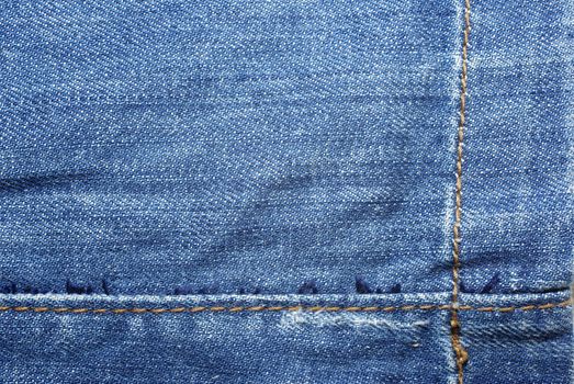 Blue jeans with yellow stitches abstract textle background.