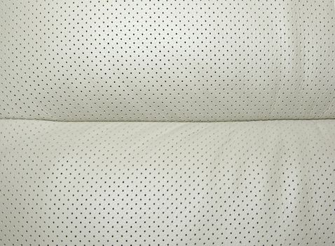 Beige perforated leather - part of modern japanese car interior. Background or backdrop.