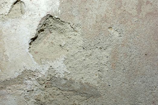 Old concrete wall with damaged plaster and alabaster on it. Abstract grunge background.