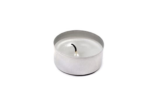 Used tea light candle close up isolated on white background.