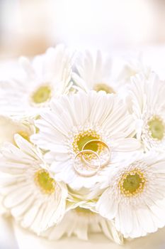 Twi wedding rings on a bouquet of white flowers