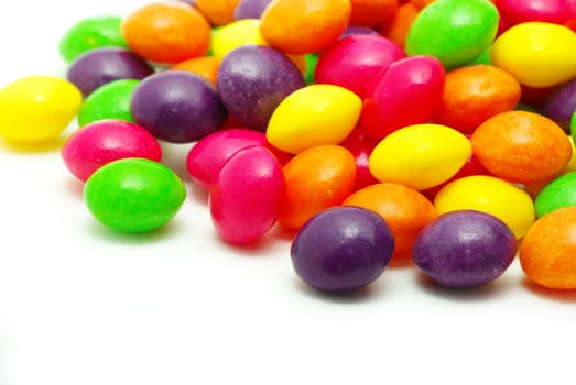 Set of sweet dragees of different color on white background