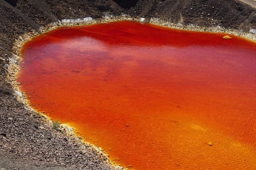 Detail of the red acid water pond in São Domingos Mine, a deserted open-pit mine in Mertola, Alentejo, Portugal. This site is one of the volcanogenic massive sulfide ore deposits in the Iberian Pyrite Belt, which extends from the southern Portugal into Spain