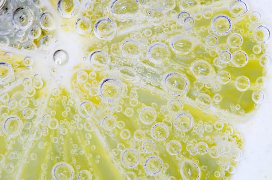 Close-up of a lemon slice with bubbles