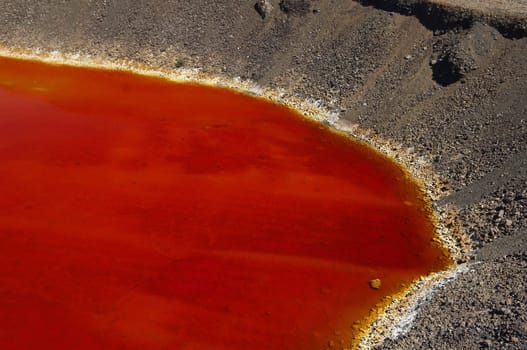 Detail of the red acid water pond in São Domingos Mine, a deserted open-pit mine in Mertola, Alentejo, Portugal. This site is one of the volcanogenic massive sulfide ore deposits in the Iberian Pyrite Belt, which extends from the southern Portugal into Spain