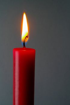 Red (isolated)  lighted candle in gray background with clipping path