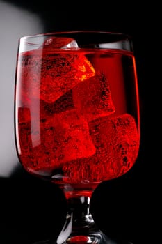 Glass of red drink with ice closeup (4)