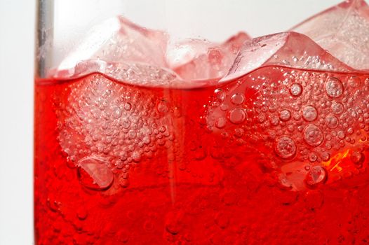 Glass of red drink with ice closeup (3)