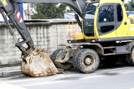 road construction equipment buck hoe parked along the street 