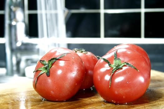 tomatoes on a black tile  background with running water