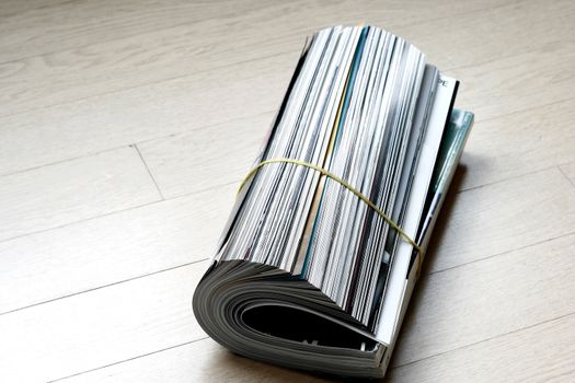 close up of rolled up magazine on a wooden tile
