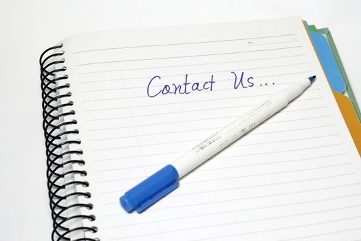 Contact Us written on a notebok with pen