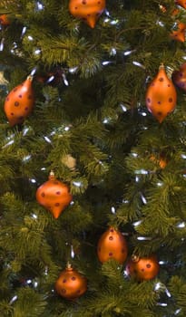 Closeup image of a Christmas tree deocrated with orange balls.