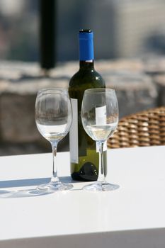 two wine glasses and a bottle in a siny day