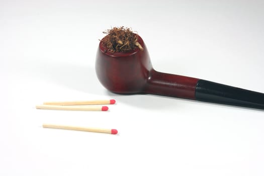 old wooden tobacco pipe with matches in white background