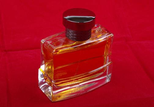Luxury perfume glass bottle isolated on red background.