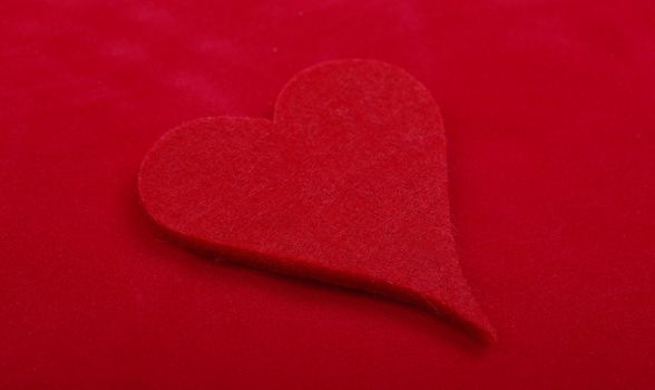 Close up studio shot of heart object isolated on red background. Love concept.