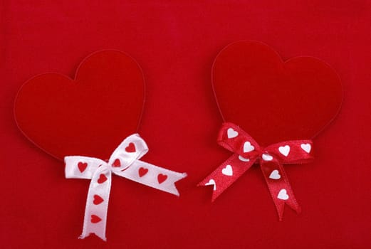 Two handmade hearts isolated on red background. Abstract love backdrop.
